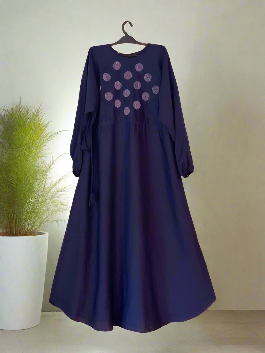 Navy blue dress with floral patterns on a hanger against a neutral background